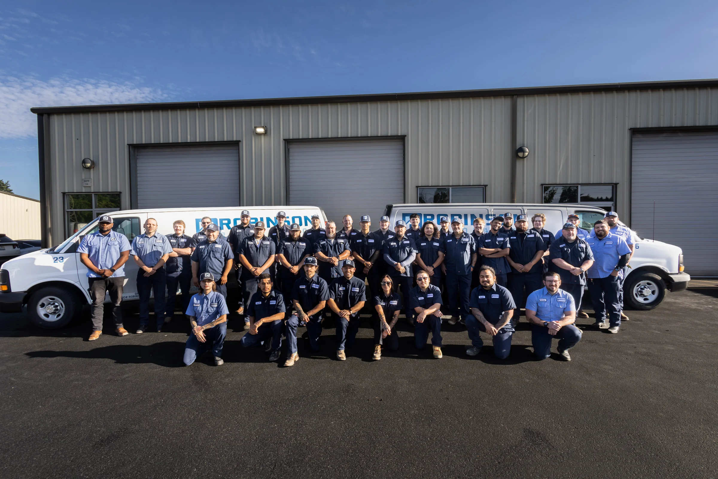 The Robinson Restoration team in front of their Vancouver shop with service vans